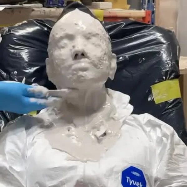 A sculpted figure being finished by hand